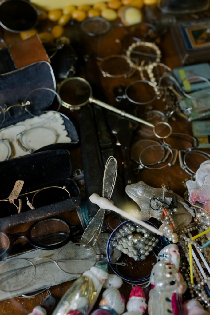 A close-up view showcasing a diverse collection of vintage and antique items, including eyewear and jewelry.